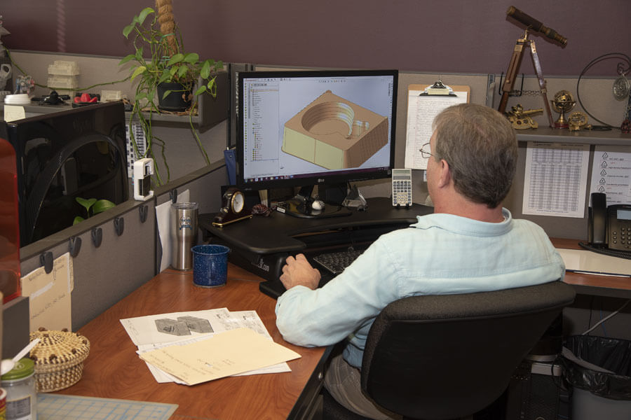 Man in blue collared shirt looks at 3D rendering