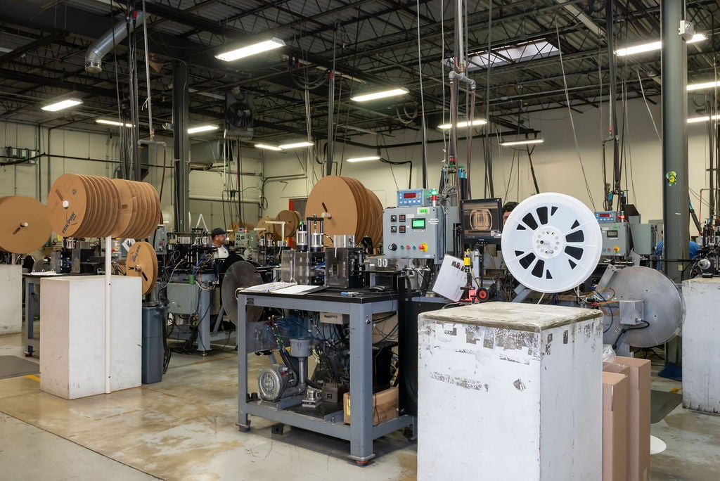 Interior photo of the Tek Pak Inc Tape and Reel facility with rolls and tables