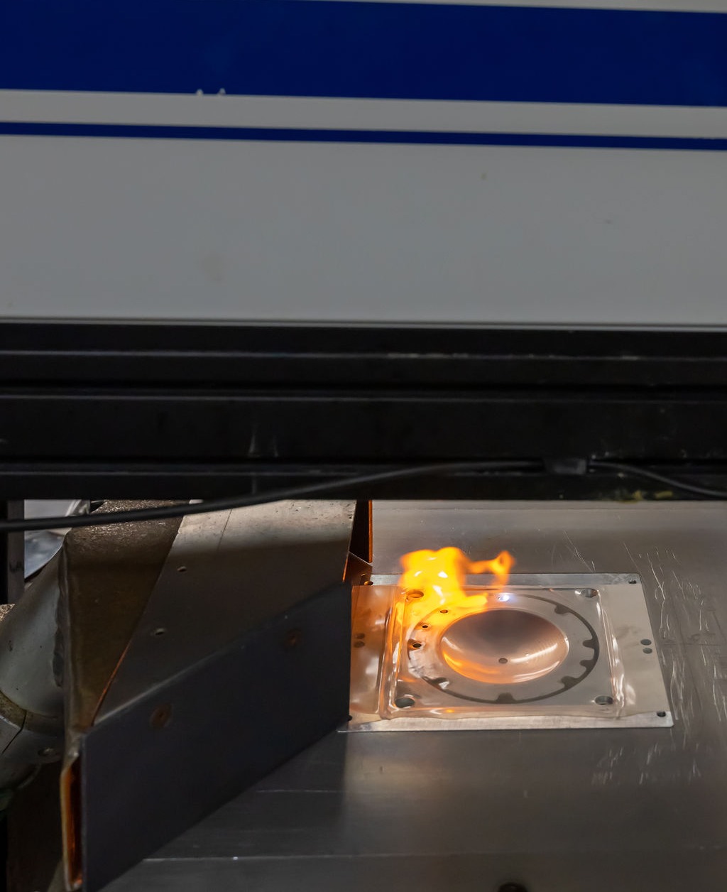 Close up of laser trimmer finely cutting a thermoformed tool. Fire can be see from the heat