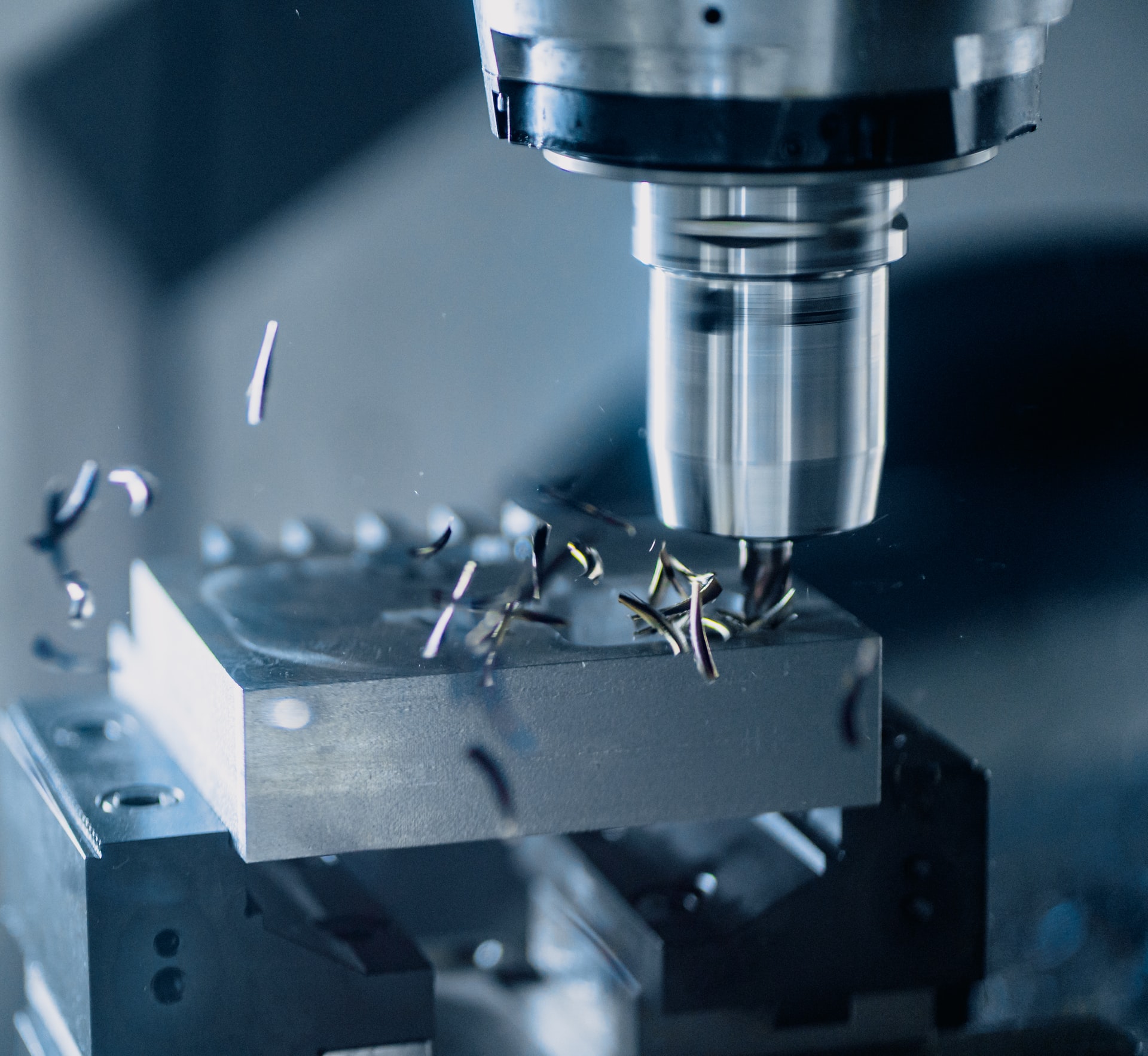 Close up photo of a metal blank being shaped by a drill press