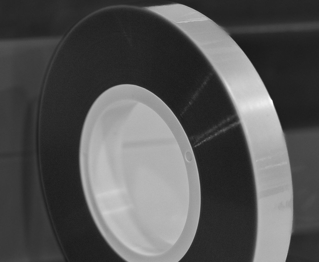 Close up picture of a spool of grey cover tape