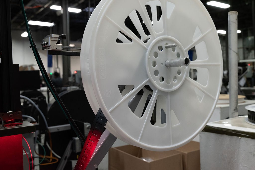 Close up picture of white plastic spool of custom carrier tape