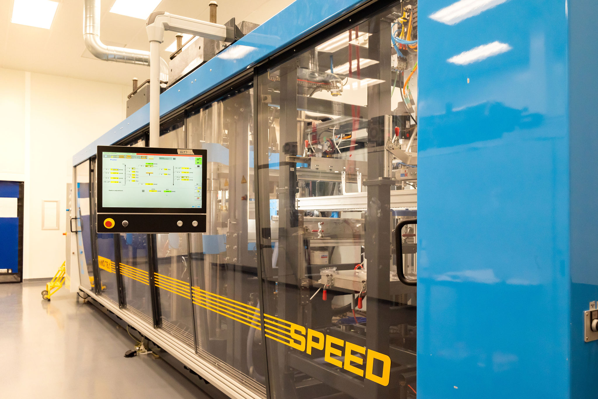 Tek Pak Kiefel thermoforming machine in blue with the word speed written on the side in yellow.