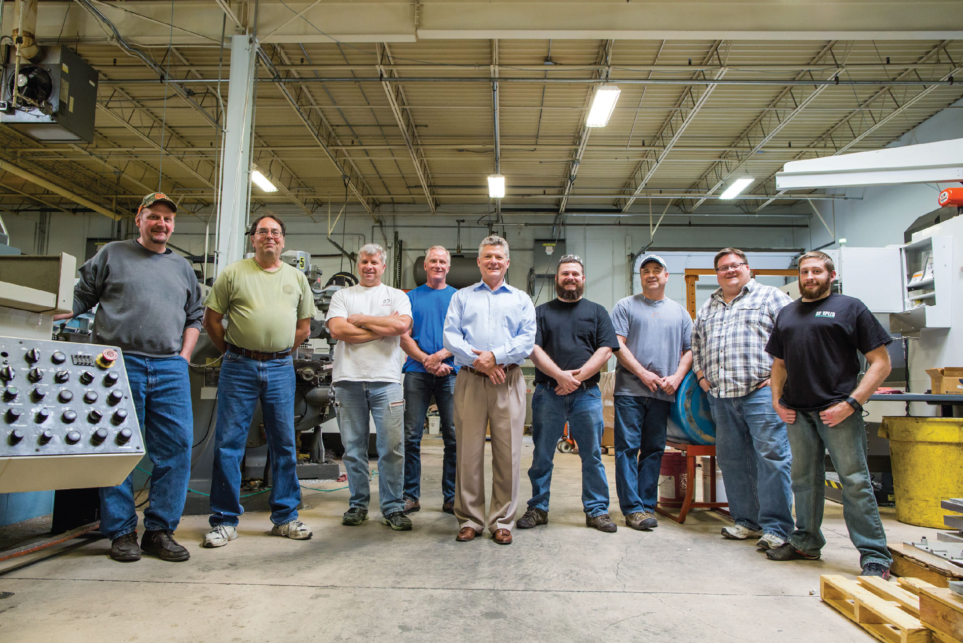 Owner of Tek Pak Tony Beyer (middle) stands with other Tek Pak employees